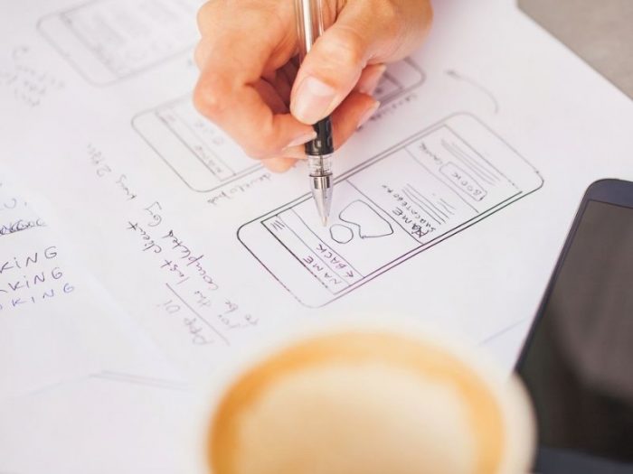 Hand sketching website wireframes on paper