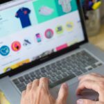 Person using a laptop to browse an online shop with clothing and product listings